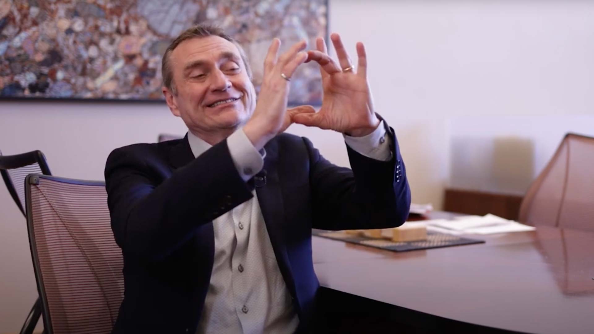 Man making an 'o' shape with his hands.